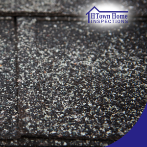 Large hailstone on asphalt shingle roof, highlighting potential storm damage risks